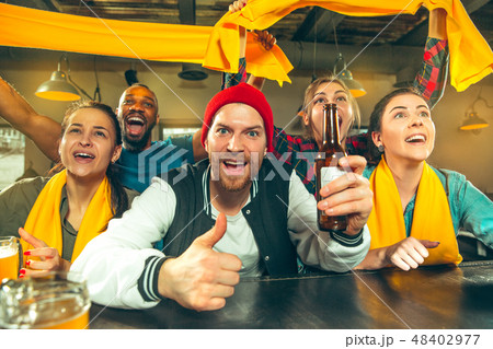 Sport, people, leisure, friendship and entertainment concept - happy football fans or male friends Sport, people, leisure, friendship and entertainment concept - happy football fans or male friends 48402977