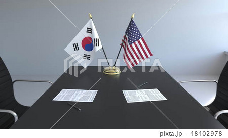 Flags of South Korea and the United States and papers on the table. Negotiations and signing an Flags of South Korea and the United States and papers on the table. Negotiations and signing an 48402978