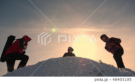 team work and victory. Tourists come to top of snowy hill and rejoice at victory against backdrop of team work and victory. Tourists come to top of snowy hill and rejoice at victory against backdrop of 48403195