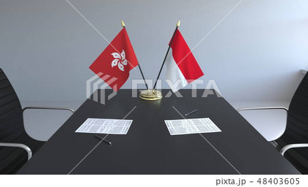 Flags of Hong Kong and Indonesia and papers on the table. Negotiations and signing an international Flags of Hong Kong and Indonesia and papers on the table. Negotiations and signing an international 48403605