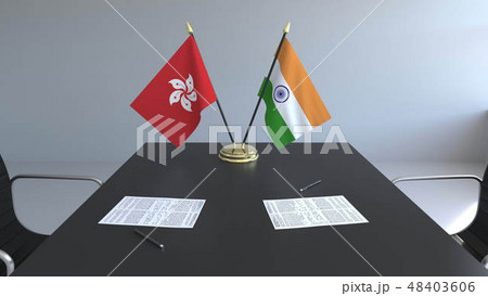 Flags of Hong Kong and India and papers on the table. Negotiations and signing an international Flags of Hong Kong and India and papers on the table. Negotiations and signing an international 48403606