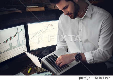 Man compares figures and charts and the stock market Man compares figures and charts and the stock market 48404397
