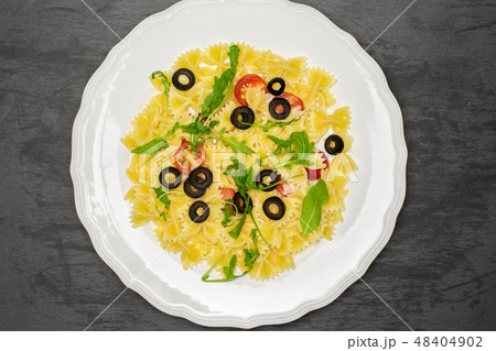 Recipe farfalle with arugula leaves on grey stone 48404902