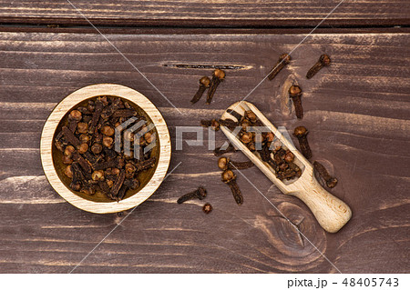 Small dried cloves spice on brown wood 48405743