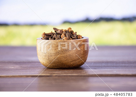 Small dried cloves spice with field behind Small dried cloves spice with field behind 48405783