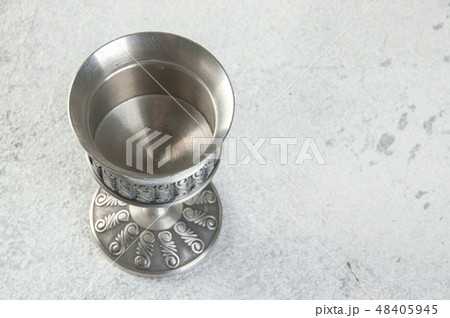 Vintage pewter goblet on concrete background. Vintage pewter goblet on concrete background. 48405945