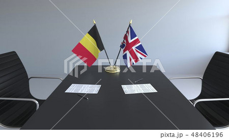 Flags of Belgium and Great Britain and papers on the table. Negotiations and signing an Flags of Belgium and Great Britain and papers on the table. Negotiations and signing an 48406196
