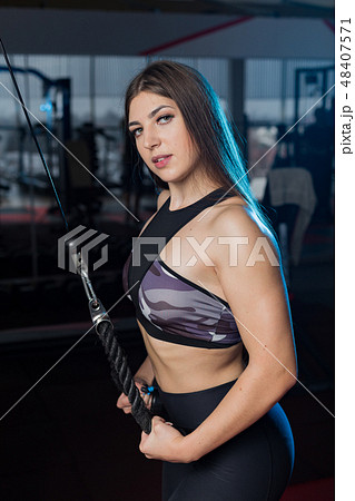 girl in a gym doing triceps exercises on block girl in a gym doing triceps exercises on block 48407571