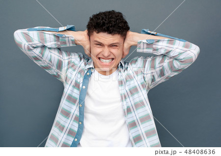 Man isolated on gray wall free style standing covering ears irritated 48408636