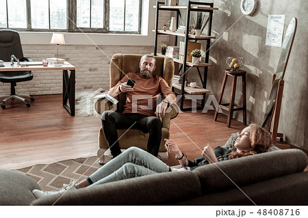 Bearded psychologist using his smartphone during therapy 48408716