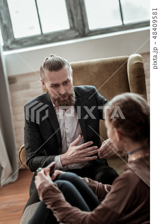 Bearded psychologist giving instructions to stressed teenager Bearded psychologist giving instructions to stressed teenager 48409581