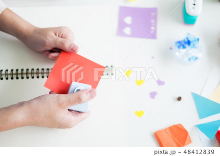 Woman's hand cut paper Making a scrap booking or other festive d 48412839