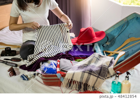 Woman hand packing a luggage for a new journey and travel for a 48412854