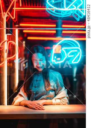 Beautiful girl in a window cafe and looks at the camera Beautiful girl in a window cafe and looks at the camera 48416412