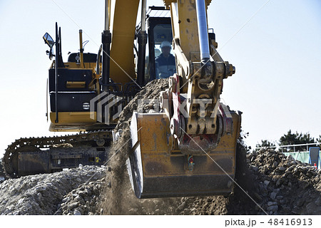 バケットいっぱいに土を掘削する重機 48416913
