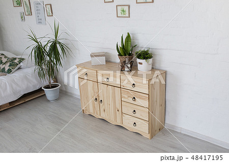 Interior living room with a wooden chest on a white brick wall 48417195