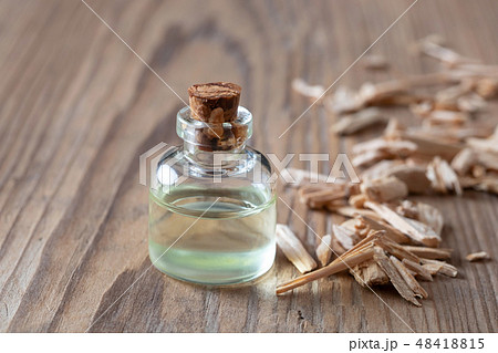 A bottle of cedar essential oil with cedar wood 48418815
