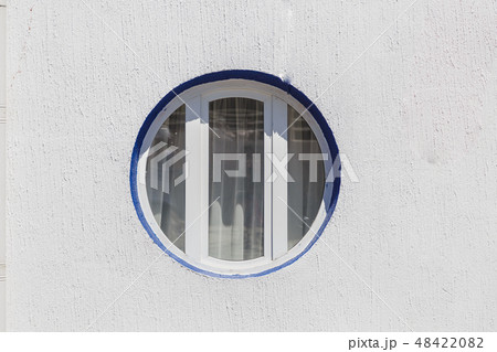 Round and vintage shape of glass window on a brick 48422082