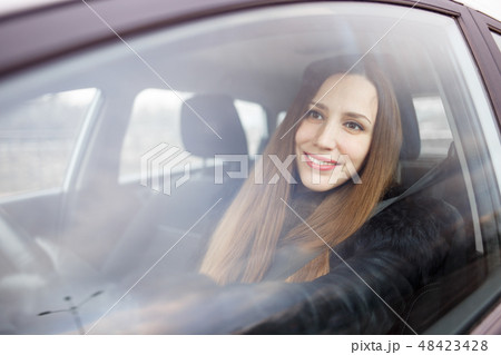 Young lady driving a car in winter Young lady driving a car in winter 48423428