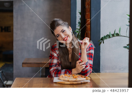 Beautiful and sexy girl sitting at a table with a Beautiful and sexy girl sitting at a table with a 48423957
