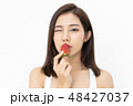 Portrait of a beautiful Asian girl kissing a fresh strawberry an 48427037