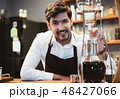 Handsome barista preparing drip coffee for customer in coffee sh 48427066