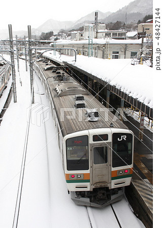 冬の水上駅を発車する上越線211系 48427144