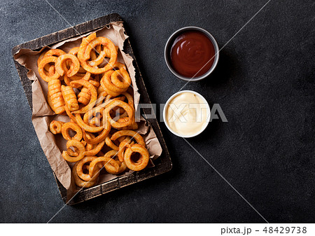 Curly fries fast food snack in wooden with ketchup Curly fries fast food snack in wooden with ketchup 48429738