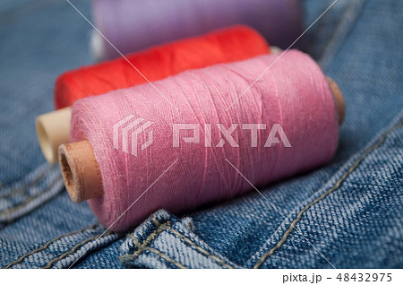 sewing thread spool bobbin on blue jeans sewing thread spool bobbin on blue jeans 48432975