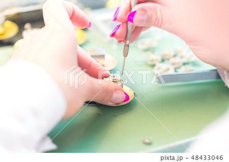 Female hand with screwdriver at industrial works 48433046