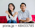asian husband and causasian wife watch tv 48433785