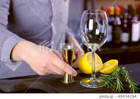 Ingredients for a cocktail with lemon and rosmary on board in bar. 48434284