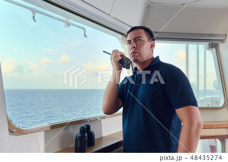 Portrait of navigator pilot officer on the bridge of the vessel Portrait of navigator pilot officer on the bridge of the vessel 48435274