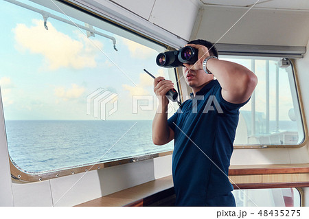 Portrait of navigator pilot officer on the bridge of the vessel Portrait of navigator pilot officer on the bridge of the vessel 48435275
