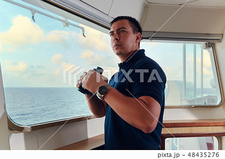 Portrait of navigator pilot officer on the bridge of the vessel Portrait of navigator pilot officer on the bridge of the vessel 48435276