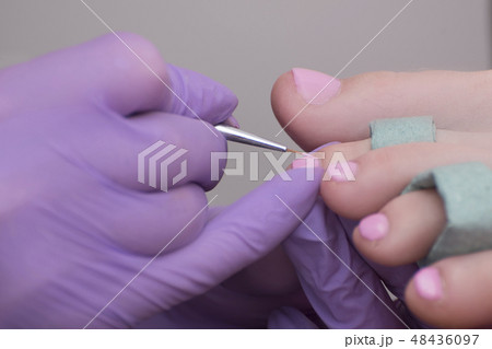 Covering toenails with pink nail polish. Close-up 48436097