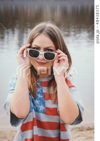A girl hippy on the river bank posing and smiling A girl hippy on the river bank posing and smiling 48438375