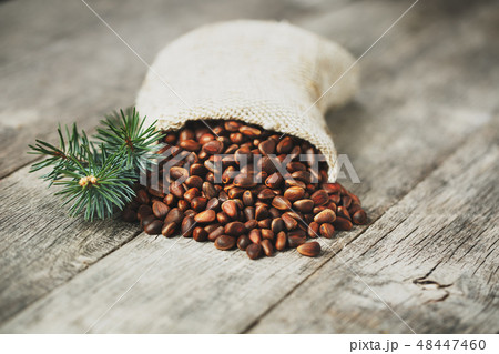 Pine nuts in a bag of burlap on an old vintage Pine nuts in a bag of burlap on an old vintage 48447460