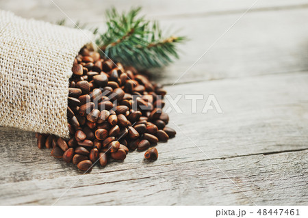 Pine nuts in a bag of burlap on an old vintage ba 48447461