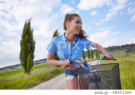 Sexy woman with vintage bike in a country road. Sexy woman with vintage bike in a country road. 48451304