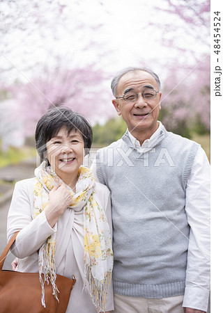 桜の中で微笑むシニア夫婦 48454524