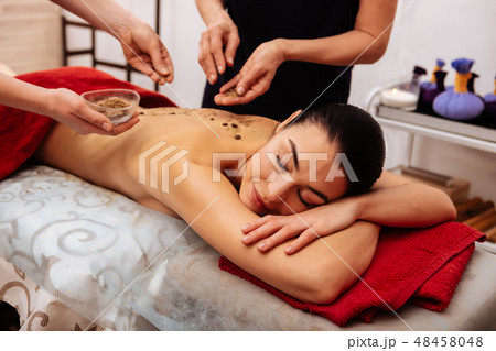 Peaceful dark-haired client being involved in beauty procedure Peaceful dark-haired client being involved in beauty procedure 48458048