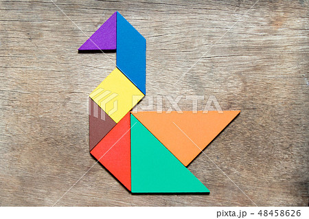 Color tangram in swan shape on wood background Color tangram in swan shape on wood background 48458626
