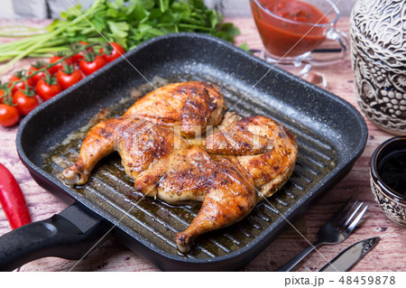 Fried chicken tobacco (tabaka) in a grill pan 48459878