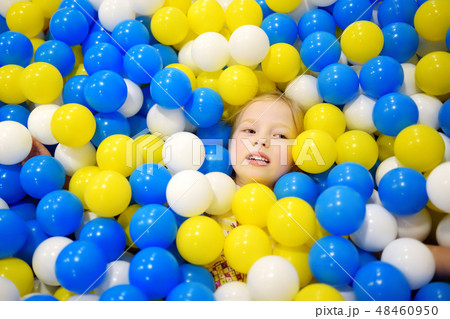 Happy little girl having fun in ball pit  48460950