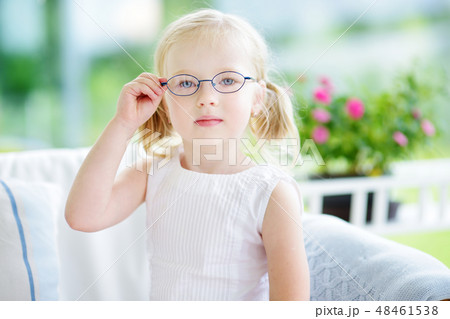Portrait of beautiful little girl wearing glasses at home Portrait of beautiful little girl wearing glasses at home 48461538