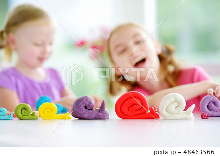 Two sisters having fun with modeling clay  48463566