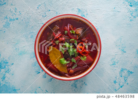 Bowl of beet soup with meat on a blue background.  48463598
