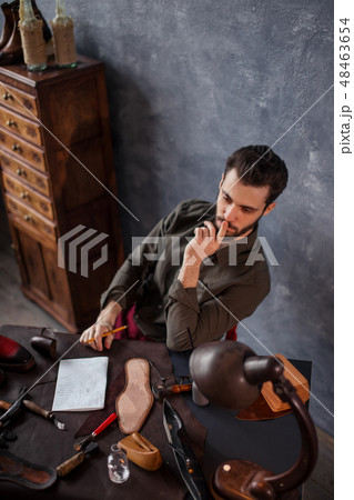 young clever man making up a new construction of the footwear young clever man making up a new construction of the footwear 48463654