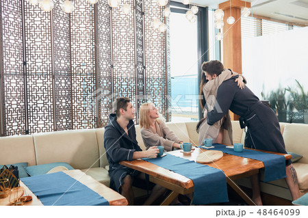 Relaxed diverse friends in bathrobes sitting at lounge zone of bathhouse 48464099